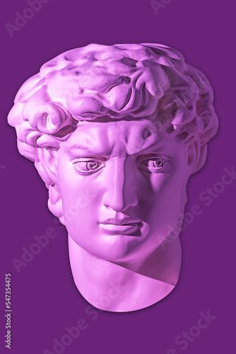 Gypsum copy of head statue David for artists isolated on purple background. Face famous sculpture youth of David by Michelangelo. Template design for dj, fashion, poster, zine. Bright violet color. © Ded Pixto
