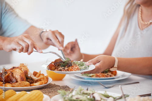 Hands, food and utensils with a couple eating a meal together at a dinner table in their home. Hand, roast and hungry with a man and woman enjoying lunch or dinner while bonding in a house closeup
