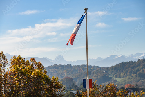 Foto Drapeau flotte avec la chaîne des Pyrénées avec  en arrière plan l'Ossau,  Pau,