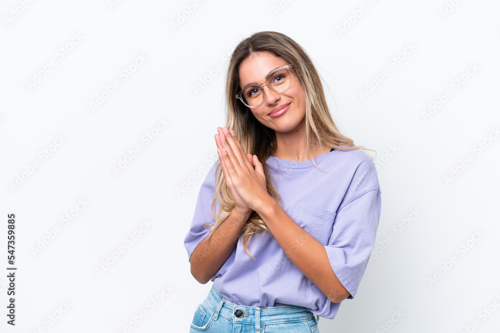 Young Uruguayan woman isolated on white background keeps palm together. Person asks for something Young Uruguayan woman isolated on white background keeps palm together. Person asks for something
