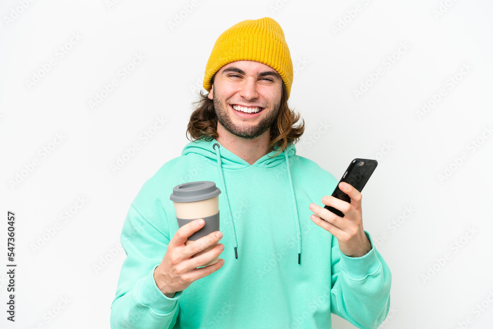 Young handsome man isolated on white chroma background holding coffee to take away and a mobile Young handsome man isolated on white chroma background holding coffee to take away and a mobile