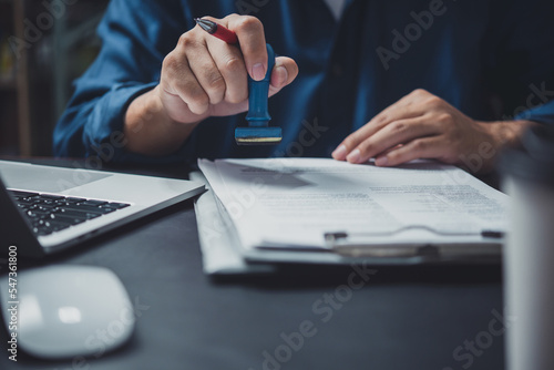 Foto Man stamping approval of work finance banking or investment marketing documents on desk