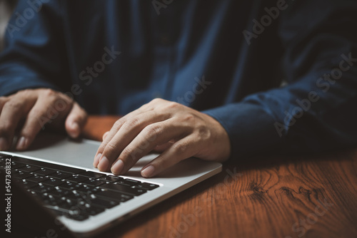 Man hands typing on laptop keyboard at the office.