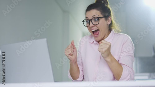 Happy successful female student receiving educational test results on laptop, successfully passing all exams and receiving tuition grant, invitation for an internship
