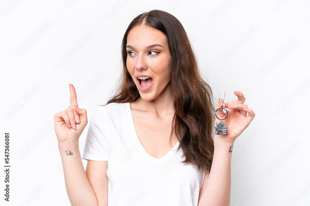 Young caucasian woman holding home keys isolated on white background intending to realizes the solution while lifting a finger up Young caucasian woman holding home keys isolated on white background intending to realizes the solution while lifting a finger up