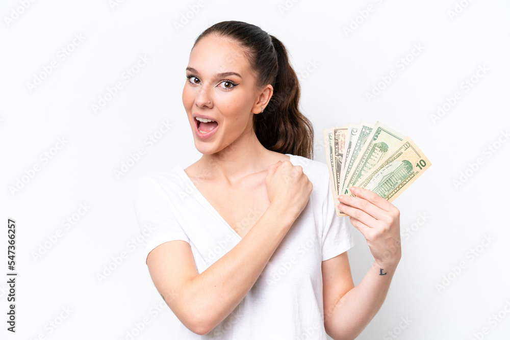 Young caucasian woman taking a lot of money isolated on white background celebrating a victory Young caucasian woman taking a lot of money isolated on white background celebrating a victory