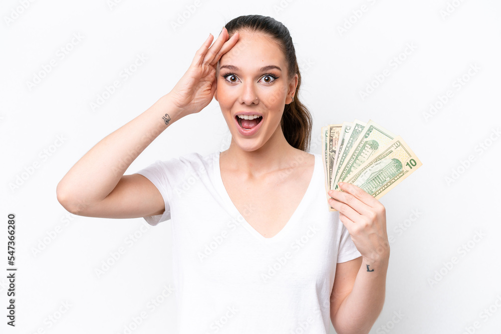 Young caucasian woman taking a lot of money isolated on white background with surprise expression Young caucasian woman taking a lot of money isolated on white background with surprise expression
