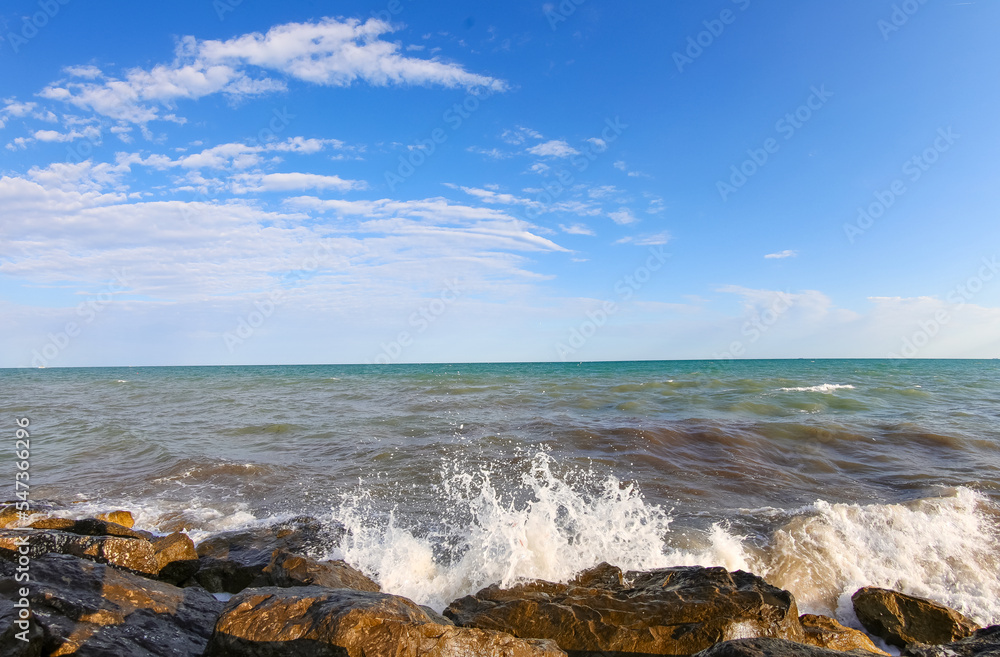 seascape with sea and rocks in summer without people and blue sky with clouds