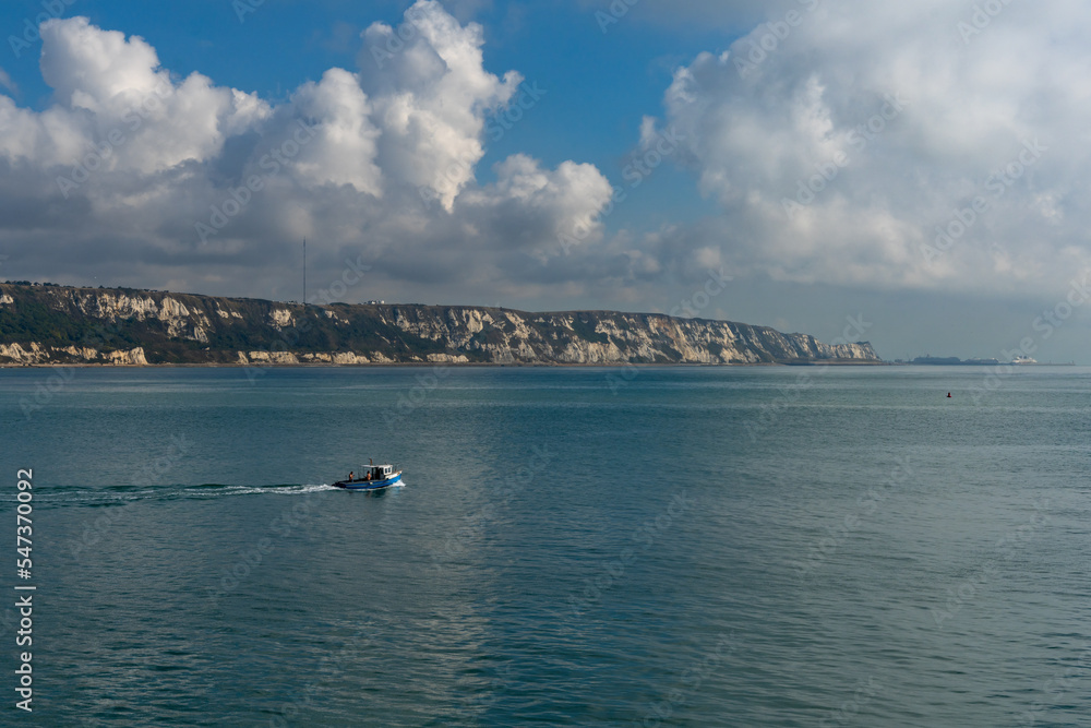 small fishing boat heading into the English Channel with the White Cliffs of Dover in the background