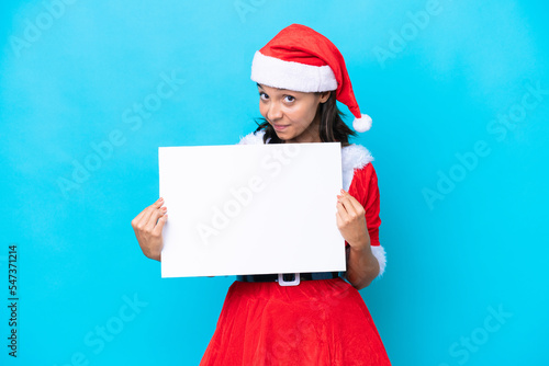 Young hispanic woman dressed as mama noel isolated on white background holding an empty placard with happy expression
