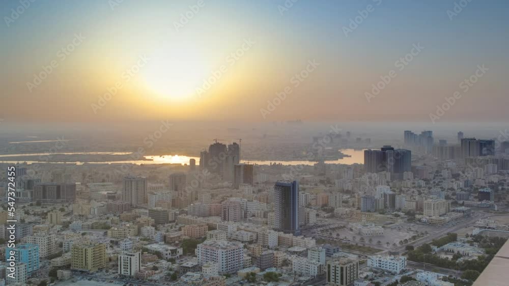 Sunrise with cityscape of Ajman from rooftop aerial timelapse. Sun over modern city. Ajman is the capital of the emirate of Ajman in the United Arab Emirates. Sunrise with cityscape of Ajman from rooftop aerial timelapse. Sun over modern city. Ajman is the capital of the emirate of Ajman in the United Arab Emirates.