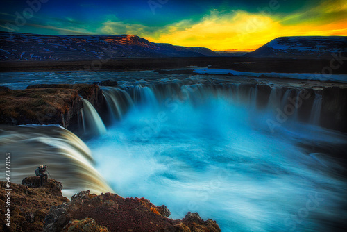 photographer at waterfall at sunset