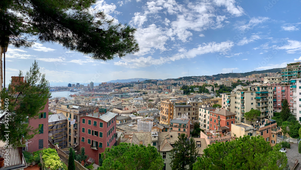 Panoramic view of Genoa in Liguria, Italy with pastel coloured houses and port in background