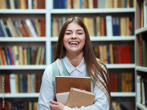 Happy student with books laughing in library