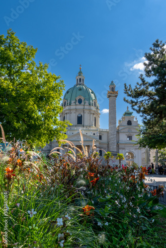 vertical view of the Karlskirche Church in downtown Vienna with colorful flowers in the foreground
