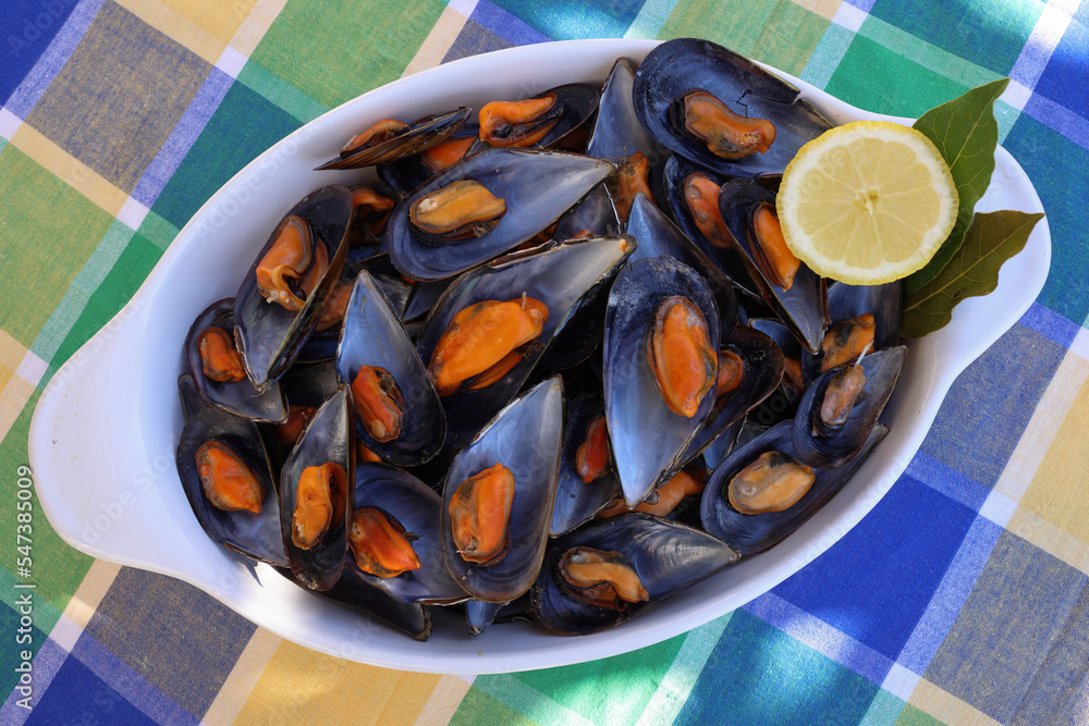 Portion of cooked mussels from the Galician estuary garnished with lemon and with natural light Portion of cooked mussels from the Galician estuary garnished with lemon and with natural light