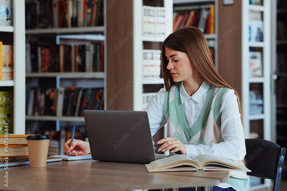 Female student using laptop in college library Female student using laptop in college library