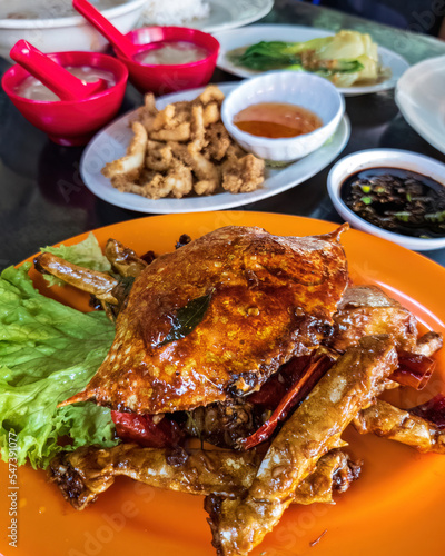 Photography Chilli mud crab served with other Chinese food on the table.