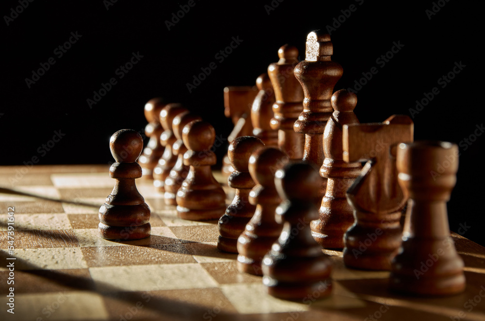 Chess pieces on a chessboard. Pawn ahead. Chess pieces on a chessboard. Pawn ahead.