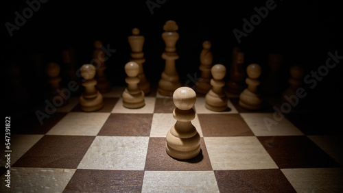 Chess pieces on a chessboard. Pawn ahead.