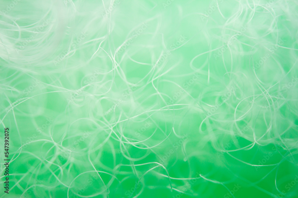 Extreme macro of polyester stable fiber on green background Extreme macro of polyester stable fiber on green background