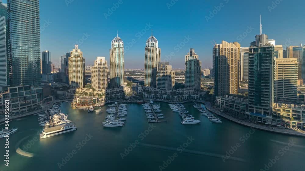 Dubai Marina skyscrapers aeral during all day timelapse until sunset, port with luxury yachts and marina promenade, Dubai, United Arab Emirates. Shadow moves very fast. Blue sky and emerald water Dubai Marina skyscrapers aeral during all day timelapse until sunset, port with luxury yachts and marina promenade, Dubai, United Arab Emirates. Shadow moves very fast. Blue sky and emerald water