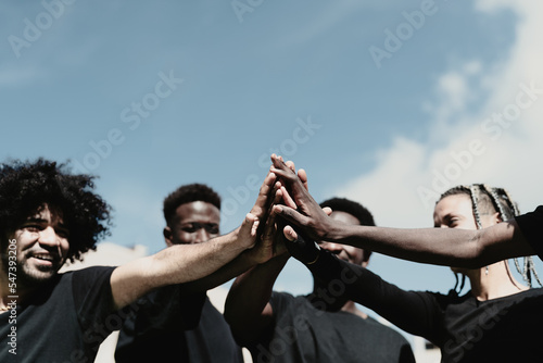 Happy group of African people having fun stacking hands together outdoor