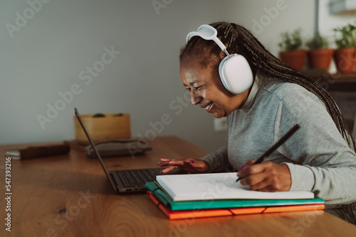 Senior African woman working on a laptop at home - Smart work and Technology concept