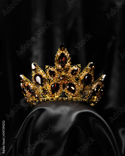 A hair ornament, a crown with a red stone, a symbol of power and beauty, on a black background