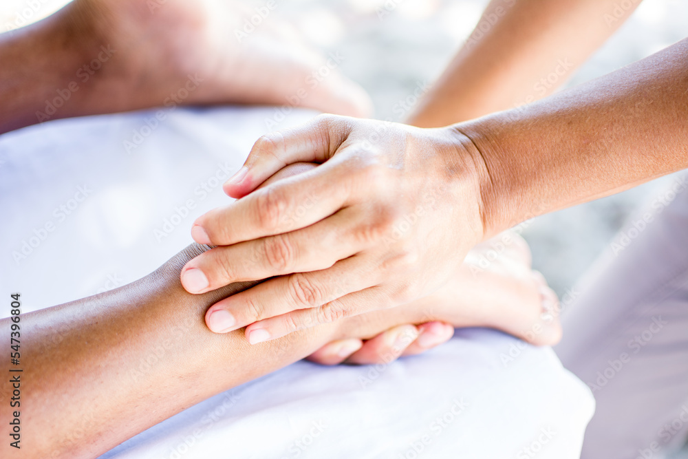 Woman receiving massage on the beach with black volcanic stones. Relaxing massage. Massage therapist. Woman receiving massage on the beach with black volcanic stones. Relaxing massage. Massage therapist.