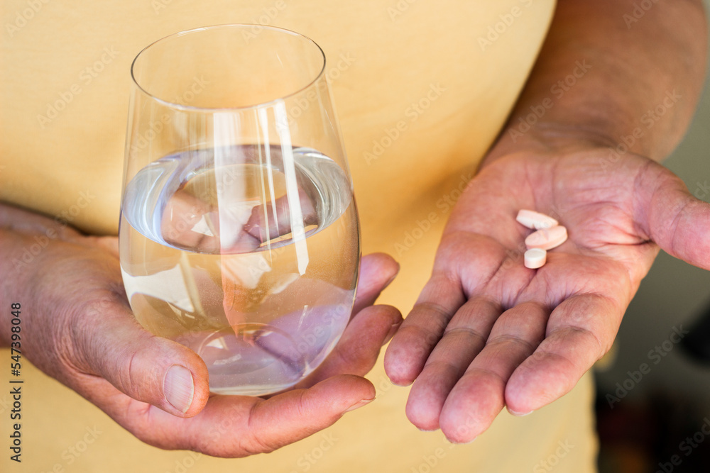 Close up view of senior woman holding vitamins and minerals pills in hand Close up view of senior woman holding vitamins and minerals pills in hand