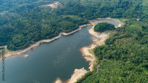 Top down from Drone aerial view of rainforest with asphalt road around the dam