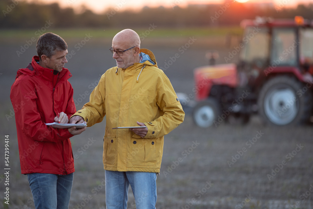 Fototapeta premium Farmers shaking hands in field in autumn