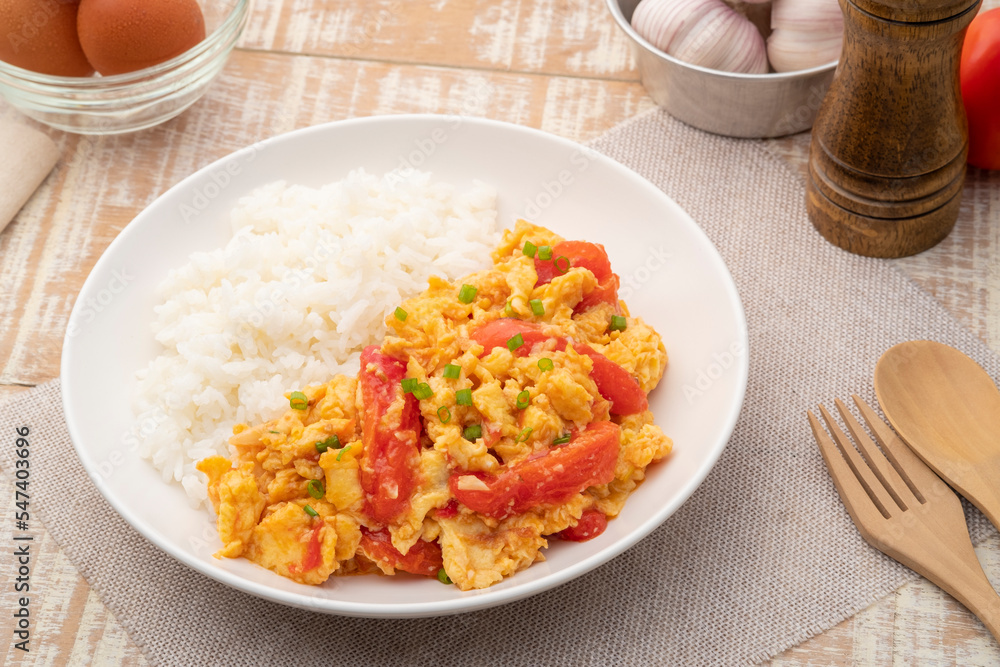 Stir fried egg with tomato,Scrambled eggs with tomatoes and cooked rice on white plate Stir fried egg with tomato,Scrambled eggs with tomatoes and cooked rice on white plate