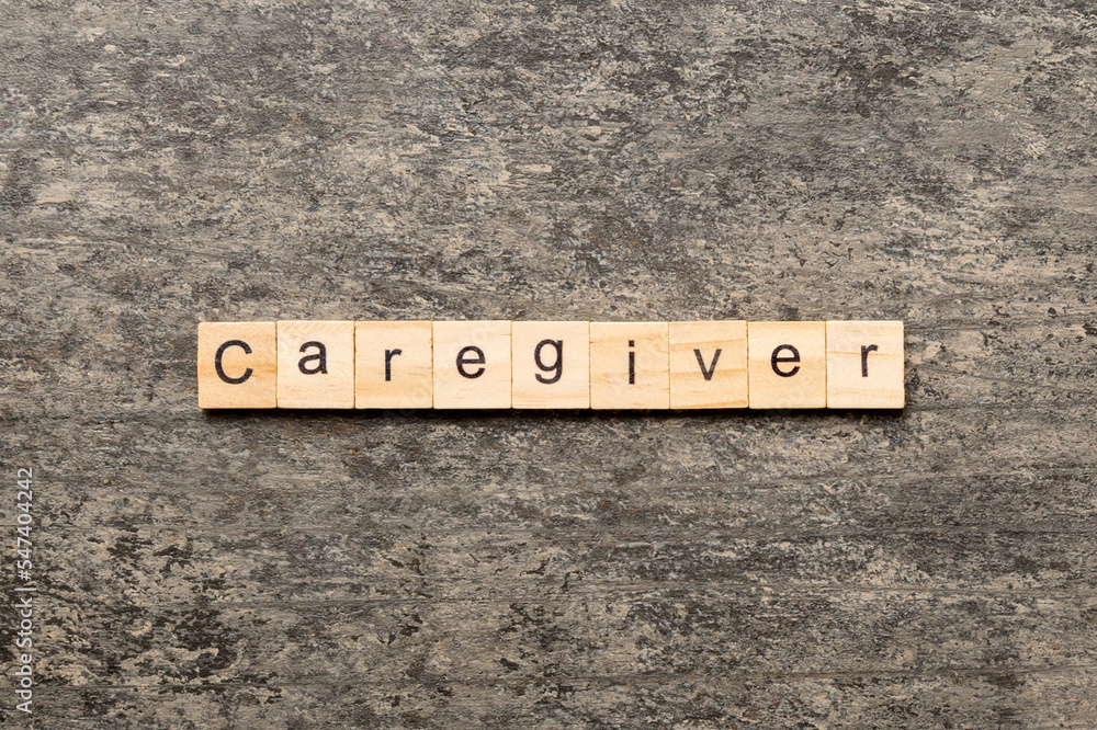 Caregiver word written on wood block. Caregiver text on table, concept Caregiver word written on wood block. Caregiver text on table, concept