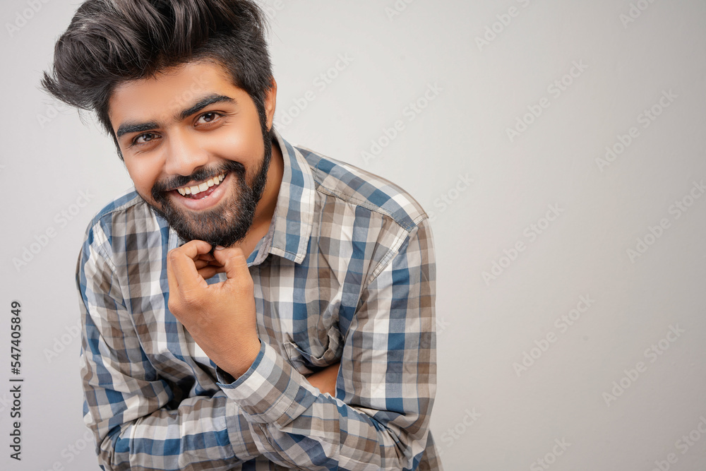 young hispanic bearded man wearing plaid shirt over white background with positive expression, has broad interested smile. Look there, please.looking for something or found something young hispanic bearded man wearing plaid shirt over white background with positive expression, has broad interested smile. Look there, please.looking for something or found something
