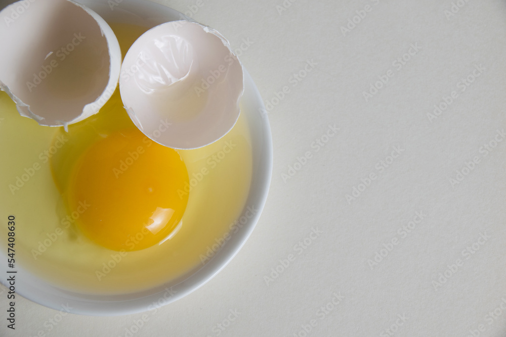 Egg yolk and shell on a plate isolate on a white background Egg yolk and shell on a plate isolate on a white background