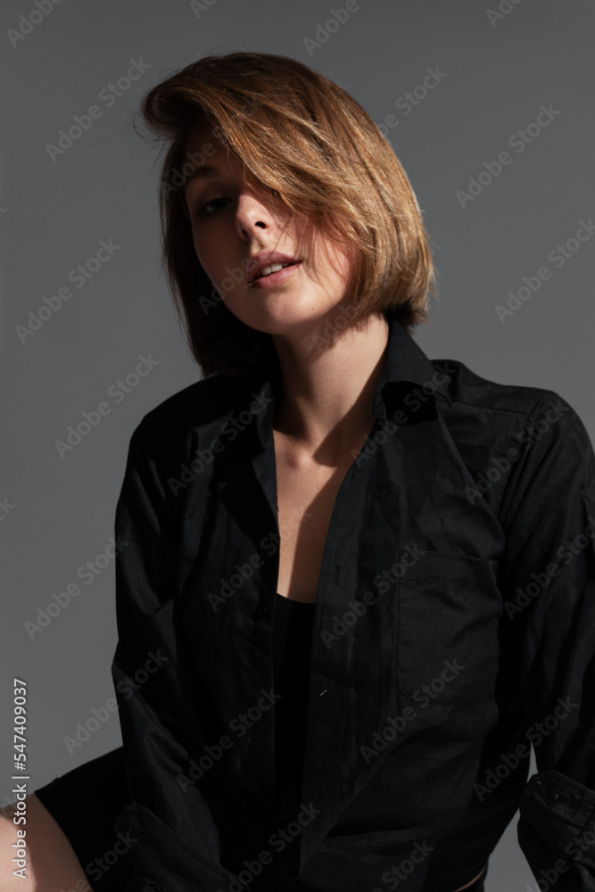 Young woman in black shorts and top posing in the studio Young woman in black shorts and top posing in the studio
