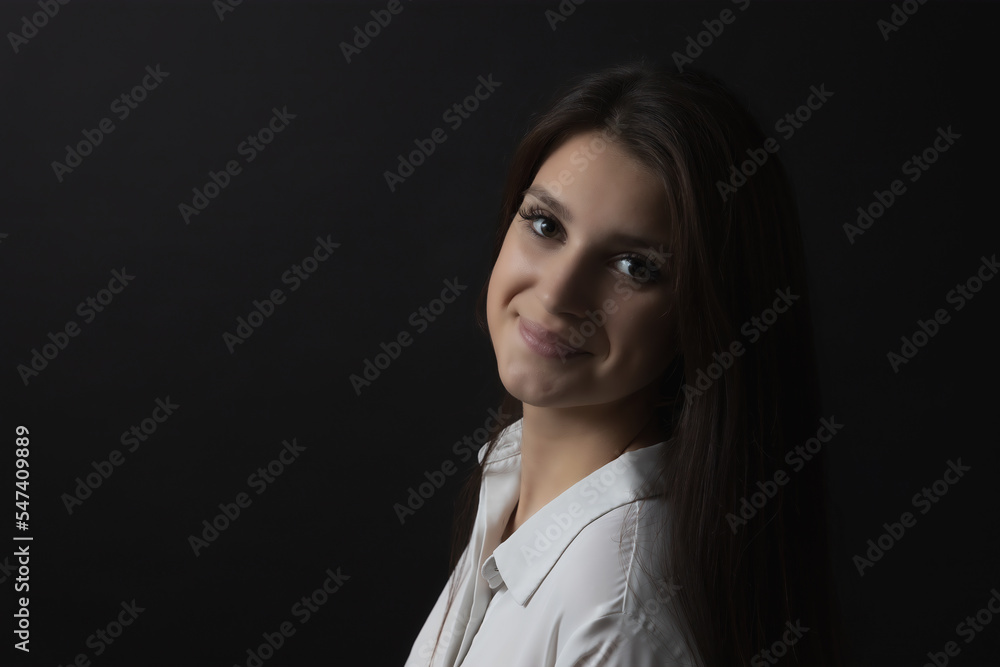 Smiling beautiful girl. Low key studio portrait. Horizontally. Smiling beautiful girl. Low key studio portrait. Horizontally.