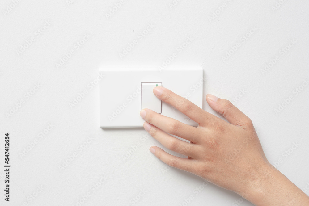 Woman hand pushing light switch at home, energy saving, copy space Woman hand pushing light switch at home, energy saving, copy space