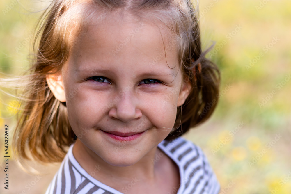 Smiling little girl in the park. Copy space. Happy child looking at the camera. Portrait of a laughing kid outside. Smiling little girl in the park. Copy space. Happy child looking at the camera. Portrait of a laughing kid outside.