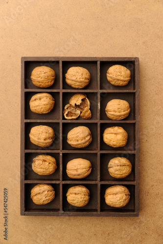 box with compartments filled with walnuts, one broken