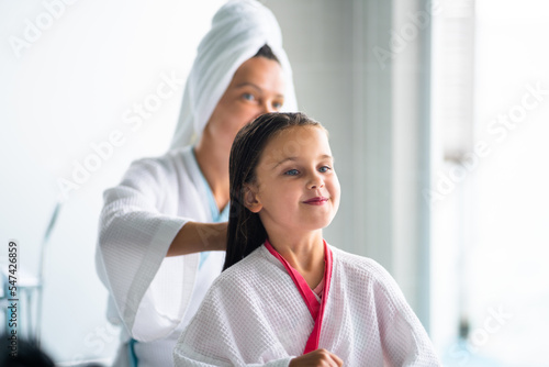 Mom Brushing Daughter Hair. Family Spa