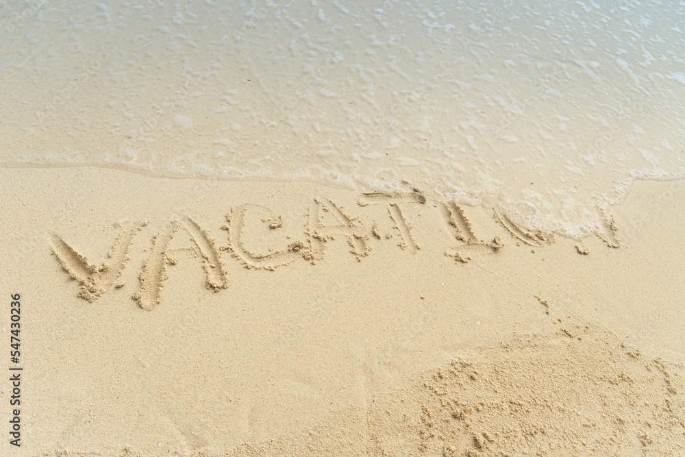 Word Vacation on beach - summer concept background. Sea, wave, inscription vacation on the sand. The wave washes away the inscription vacation on the sand. Vacation ending concept. Word Vacation on beach - summer concept background. Sea, wave, inscription vacation on the sand. The wave washes away the inscription vacation on the sand. Vacation ending concept.