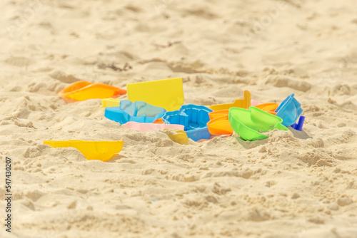Children's toys on the beach, colorful molds and paddles on the sand. Sandbox