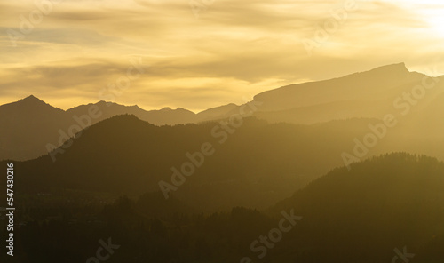 Fototapeta Naklejka Na Ścianę i Meble -  Spectacular view of mountain ranges silhouettes with yellow sunlight. Sunset in Allgau, Germany, Alps.
