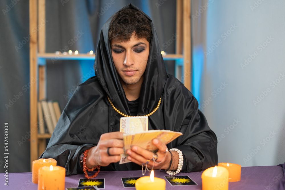 fortune teller man reading tarot cards on a table with candles. fortune teller man reading tarot cards on a table with candles.