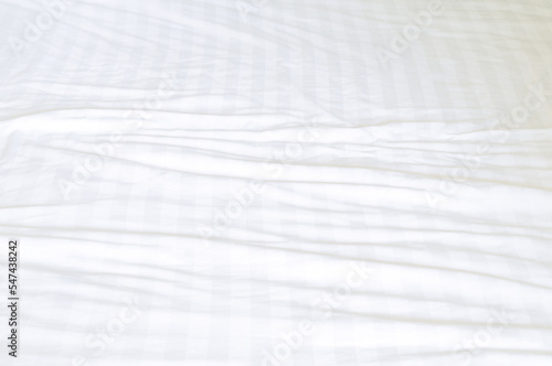 White wrinkled bedding sheet with pattern after guest s use was taken in hotel room with copy space  Untidy blanket background texture