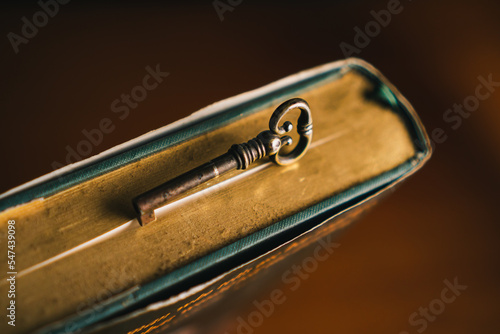vintage brass key on old dusty book