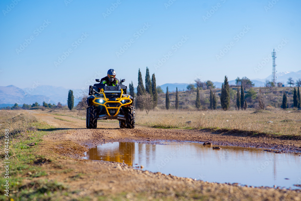 Fototapeta premium Girl driving ATV on dirt road
